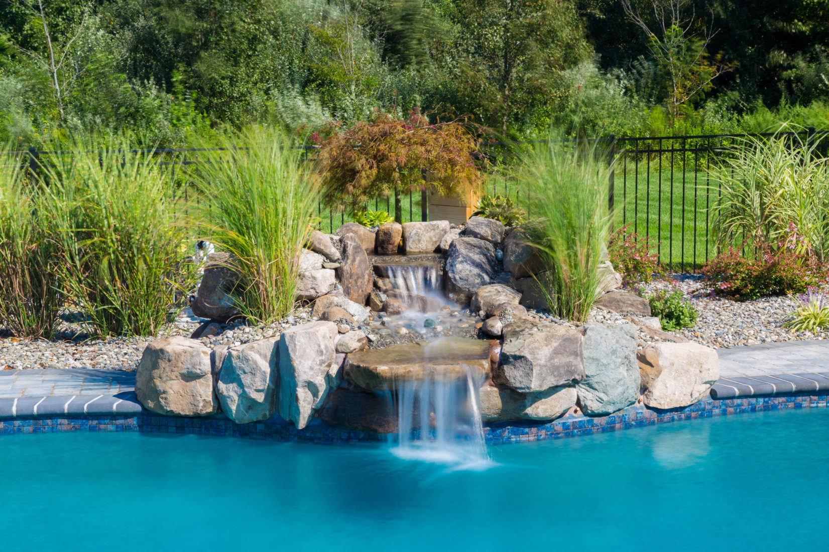 Wolfson C - Hamilton, NJ - A swimming pool with a waterfall in the middle surrounded by lush greenery