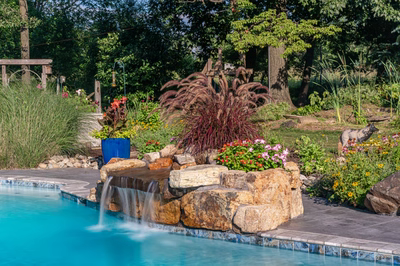 Franconia D - Malvern, PA - A swimming pool with a waterfall surrounded by colorful flowers and plants