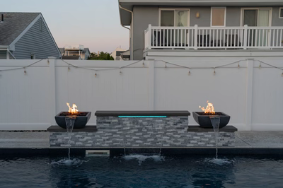Dune B - Brigantine, NJ - A modern backyard with a white fence and two fire pits with water features