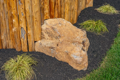 Abiqua M - Doylestown, PA - A large rock in the middle of a garden bed next to a wooden fence