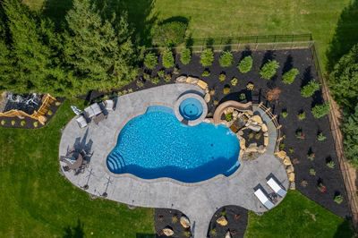 Abiqua Q - Doylestown, PA - A bird's eye view of a backyard with a swimming pool surrounded by trees and landscaping