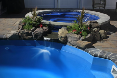 Akame A - North Beach, NJ - A blue swimming pool with a waterfall and rocks around it