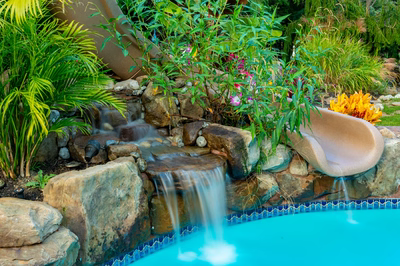 Alamere H - Colts Neck, NJ - A colorful garden with a waterfall and a water feature next to a swimming pool