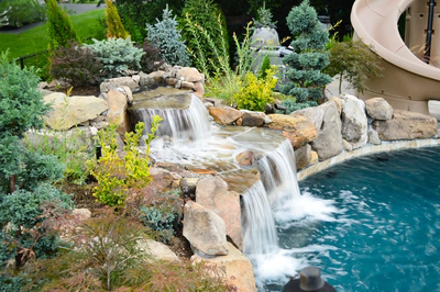 Alamosa C - Freehold, NJ - A water feature in a backyard with a pool and a water slide