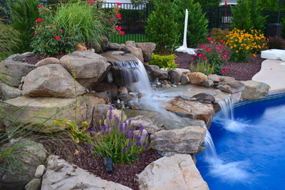 Alger D - Monroe, NJ - A rock garden with a waterfall and colorful flowers around a swimming pool
