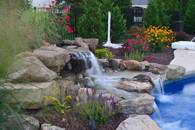 Alger E - Monroe, NJ - A backyard with a pool and a waterfall surrounded by flowers