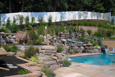 Angel M - Voorhees, NJ - A backyard with a pool, waterfall, and retaining wall