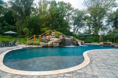 Antelope G - Ringoes, NJ - A swimming pool with a waterfall and a play area surrounded by trees