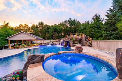 Aquatopia C - Williamstown, NJ - A beautiful backyard with a swimming pool surrounded by lush greenery and colorful flowers