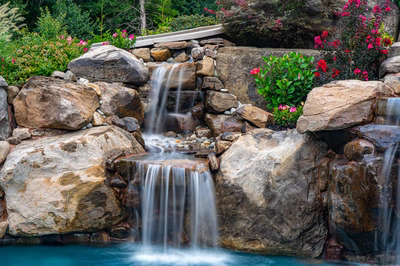 Aquatopia F - Williamstown, NJ - A beautiful garden with a waterfall surrounded by rocks and colorful flowers