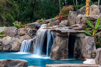 Aquatopia G - Williamstown, NJ - A beautiful garden with a waterfall surrounded by lush greenery and colorful flowers