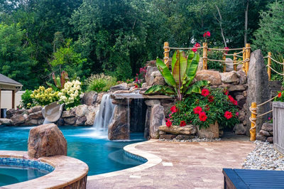 Aquatopia I - Williamstown, NJ - A beautiful backyard with a waterfall and lush greenery surrounding a swimming pool