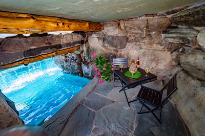 Aquatopia O - Williamstown, NJ - A glass of white wine sitting on a table in front of a stone structure with a pool in the background