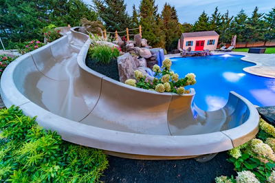 Aquatopia V - Williamstown, NJ - A backyard with a pool and a playhouse surrounded by lush greenery