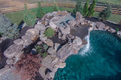 Armstrong D - Moorestown, NJ - A bird's eye view of a rock pool with a waterfall and a wooden fence surrounding it