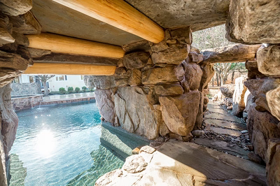 Armstrong J - Moorestown, NJ - A view of a pool through a stone structure with wooden beams