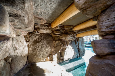 Armstrong L - Moorestown, NJ - A stone structure with wooden beams and a small pool of water.