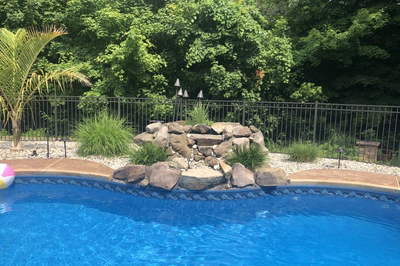 Azure A - Hillsborough, NJ - A swimming pool with a rock waterfall and a beach ball in the foreground