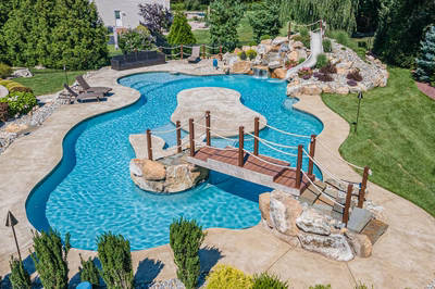 Bagley J - Williamstown, NJ - A large backyard with a swimming pool surrounded by lush greenery and rocks