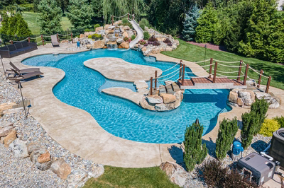 Bagley K - Williamstown, NJ - A large backyard with a swimming pool surrounded by lush greenery and rocks