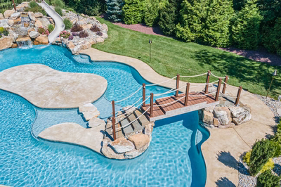 Bagley L - Williamstown, NJ - A large rectangular swimming pool with a waterfall and a wooden bridge over it