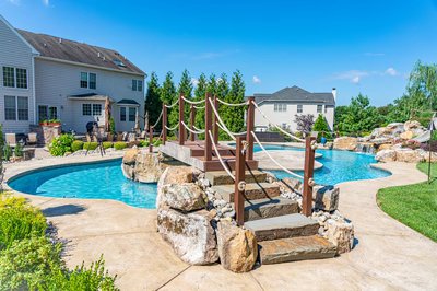 Bagley M - Williamstown, NJ - A large backyard with a swimming pool surrounded by lush greenery and rocks