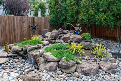 Basin F - Wenonah, NJ - A backyard garden with a waterfall surrounded by rocks and plants