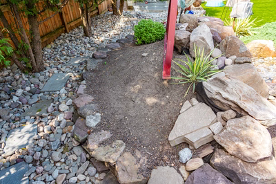 Basin K - Wenonah, NJ - A rock garden with a small shrub and a wooden fence in the background