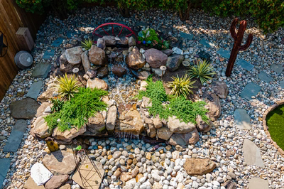 Basin L - Wenonah, NJ - A bird's eye view of a small garden with rocks, plants, and a water feature