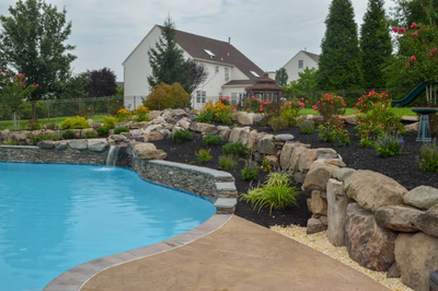 Beede D - Trappe, PA - A backyard with a swimming pool and landscaping featuring rocks and flowers