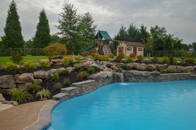 Beede E - Trappe, PA - A backyard with a swimming pool, a playhouse, and a waterfall