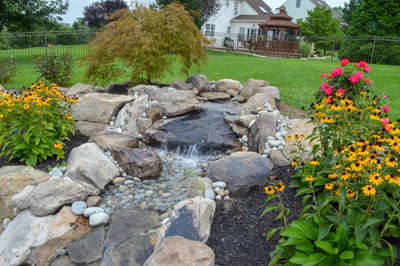 Beede I - Trappe, PA - A garden with a small waterfall surrounded by flowers and rocks