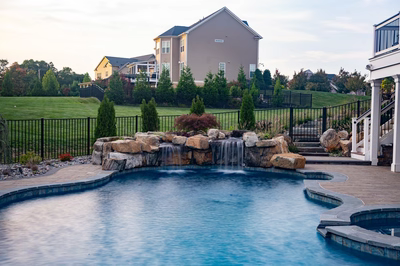 Belmore A - Highland, MD - A large backyard with a swimming pool and a waterfall feature