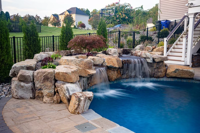 Belmore C - Highland, MD - A backyard with a swimming pool and a waterfall feature