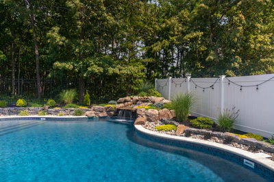 Benton H - Egg Harbor, NJ - A swimming pool surrounded by lush greenery and a waterfall.