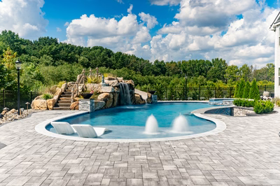 Berlin D - Robbinsville, NJ - A large rectangular swimming pool surrounded by lush greenery and a waterfall.