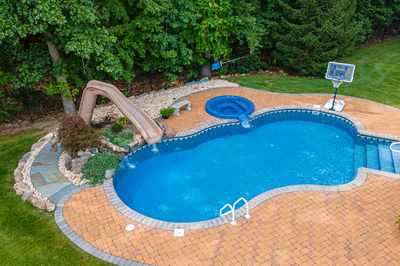 Blackwater L - Monroe, NJ - A backyard with a swimming pool, a basketball hoop, and a water feature