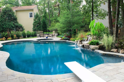 Bowman G - Medford, NJ - A swimming pool surrounded by lush greenery and a waterfall.