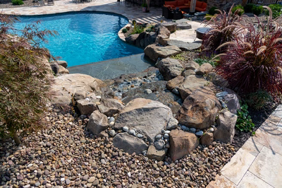 Bridge E - Lewisburg, PA - A backyard with a swimming pool surrounded by rocks and plants