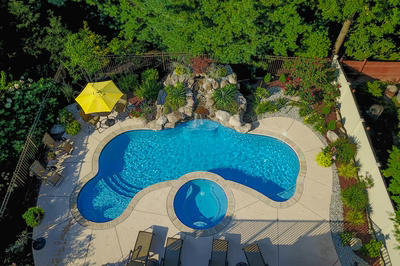 Bridgeport C - Hamilton, NJ - A bird's eye view of a swimming pool surrounded by lush greenery and a waterfall