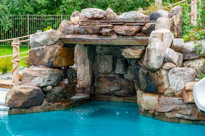 Bruar G - Millstone, NJ - A large rock structure with a waterfall in the middle of a swimming pool