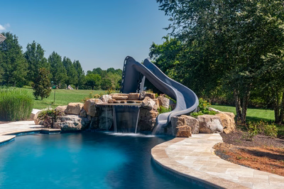 Burney - Matawan, NJ - A pool with a water slide and a waterfall in a backyard setting