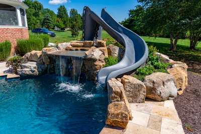 Burney - Matawan, NJ - A pool with a water feature and a slide in a backyard setting