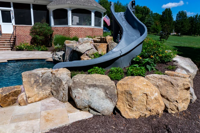 Burney - Matawan, NJ - A water slide in the middle of a rock garden next to a swimming pool