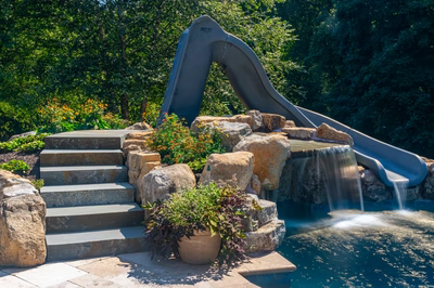 Burney - Matawan, NJ - A water slide in the middle of a lush green forest, surrounded by rocks and plants
