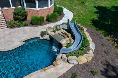 Burney - Matawan, NJ - A swimming pool with a water feature and a slide in a backyard setting