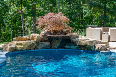 Castor B - Fallston, MD - A swimming pool with a rock waterfall in the middle surrounded by lush greenery