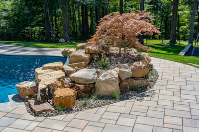 Castor E - Fallston, MD - A large rock waterfall in the middle of a pool surrounded by lush green trees
