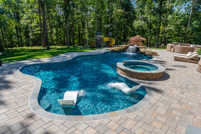 Castor L - Fallston, MD - A backyard with a swimming pool surrounded by lush green trees and a play area