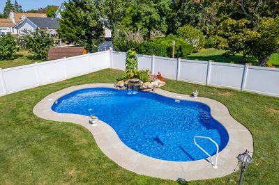 Chapel I - West Long Branch - A backyard with a swimming pool surrounded by a white fence and lush green grass